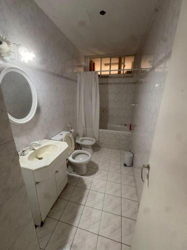 a bathroom with a sink and a toilet and a tub at Osiris Apart in Comodoro Rivadavia