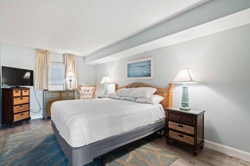 a bedroom with a large white bed and a television at Bay Watch Resort 1735 - Direct Oceanfront Balcony with Pools and Lazy River in Myrtle Beach