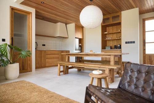 a living room with a table and a bench at The Young Villas Tropical Villas in Seseh in Canggu