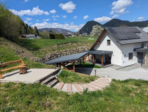 a house with solar panels on the roof at MY TIME BLED Holiday House with sauna in Zgornje Gorje