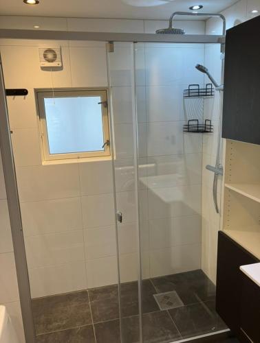 a shower with a glass door in a bathroom at Ferieleilighet Kragerø in Kragerø