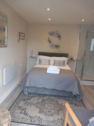 a bedroom with a bed with towels on it at Mudeford Gem Accommdation in Christchurch