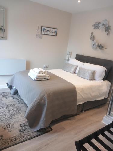 a bedroom with a large bed with towels on it at Mudeford Gem Accommdation in Christchurch