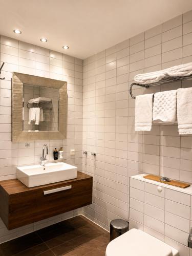 a white bathroom with a sink and a toilet at Grand Hôtel Mölle in Mölle