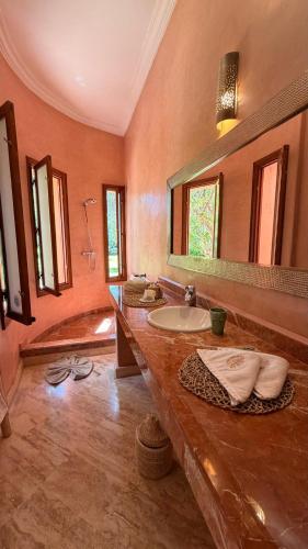 a bathroom with a sink and a large mirror at Villa Amazonika By La Siredrah in Segraga