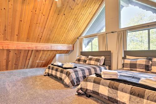 two beds in a room with wooden walls and windows at Pine Mountain Lake Cabin w/ Grill! in Groveland
