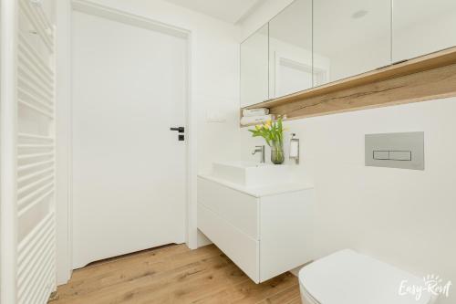 a white bathroom with a sink and a toilet at Prestige 113 - tuż przy plaży, z widokiem na morze, parkingiem i WiFi w cenie pobytu - Easy-Rent Apartments in Pobierowo