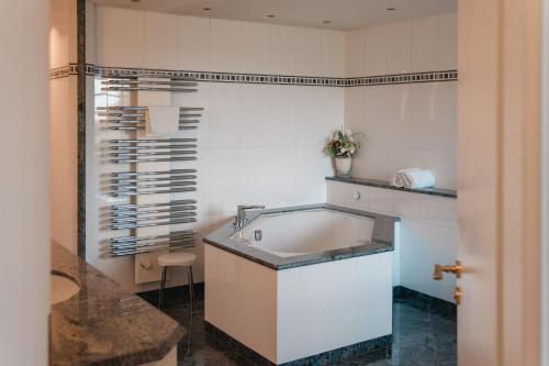 a bathroom with a tub and a sink at Hotel Hofgut Georgenthal in Burg Hohenstein