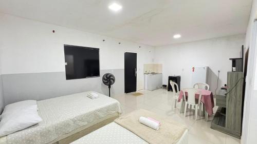 a bedroom with two beds and a flat screen tv at Villa Marçal in São Mateus