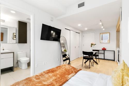 a bedroom with a bed and a bathroom with a table at Luxury Apartments with View & Indoor Heated Pool in Montreal