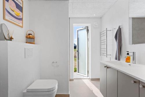 a white bathroom with a toilet and a sink at LN2067-Hjorring-Gabet-7 in Lønstrup