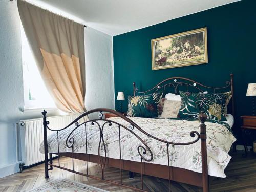a bedroom with a bed with blue walls at Bella's Eden in Grimma
