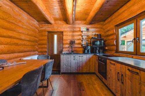 a kitchen in a log cabin with a wooden ceiling at Holzhaus in Sadu