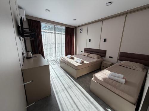 a bedroom with two beds and a large window at Park Avenue Kobuleti in Kobuleti
