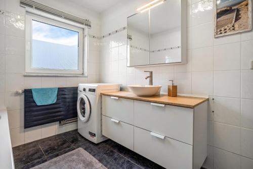 a bathroom with a sink and a washing machine at Ferienwohnung 3 in Gribow