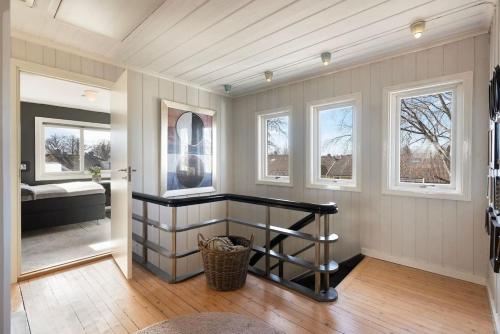a room with a hallway with a bed and windows at Seaside House 5 BR in Garder
