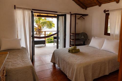 a bedroom with a bed and a door to a balcony at Los Cocos de Vichayito in Vichayito