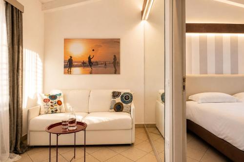 a living room with a white couch and a bed at Capo Vaticano Suites in Capo Vaticano
