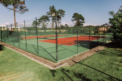 a tennis court with a net on a tennis court at Casa da Barca Pool & Golf by TonsdeVerde in Esposende