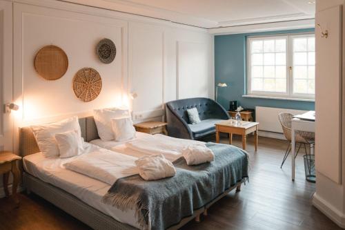 a bedroom with a bed and a living room at Hotel Hofgut Georgenthal in Burg Hohenstein