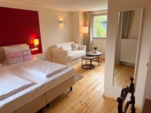 a bedroom with a bed and a living room at Gasthaus Breitenbach in Bad Brückenau