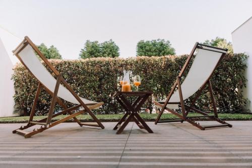 two chairs and a table with drinks on it at Casa da Barca Pool & Golf by TonsdeVerde in Esposende