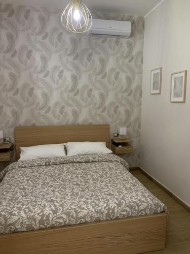 a bedroom with a bed and a wall at Etna Guest House in Belpasso