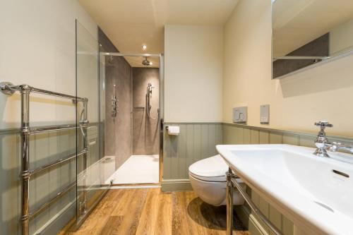 a bathroom with a toilet and a sink and a shower at Damson Dene Hotel in Bowness-on-Windermere