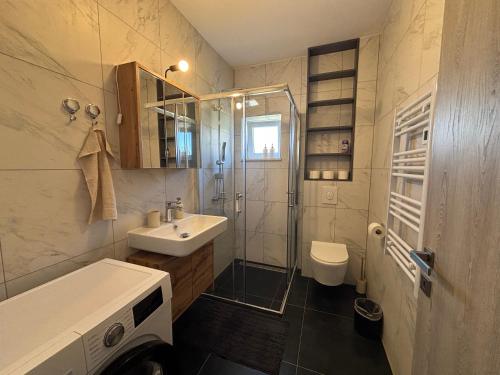 a bathroom with a shower sink and a toilet at Apartman Bugenvila Postira Brač in Postira