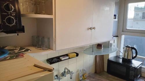 a kitchen with white cabinets and a microwave at Depto Brown in Mar del Plata