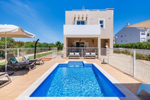 a villa with a swimming pool and a house at Roots Villa - Casa das Árvores in Cabanas de Tavira