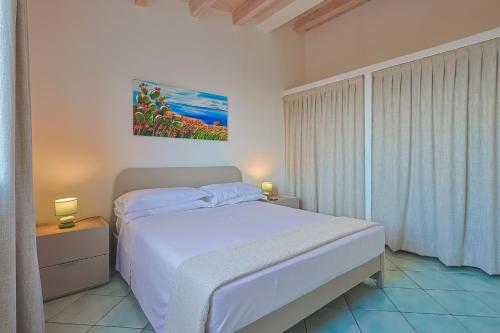 a bedroom with a bed and a painting on the wall at Passione Mare in Porto Palo