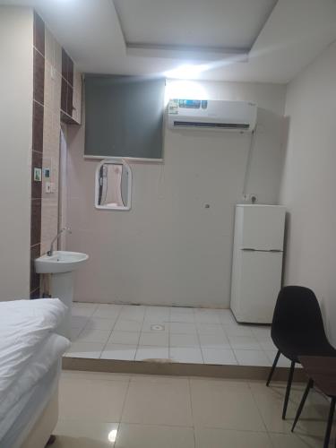 a small room with a bed and a sink and a refrigerator at مؤسسة علي عايض سداح الدوسري للمقاولات in Abu Arish