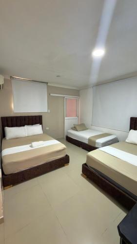two beds in a room with at Hotel Girasol Inn Barranquilla in Barranquilla