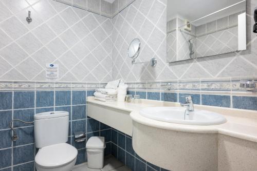 a blue tiled bathroom with a toilet and a sink at Ona el Marqués in Puerto de Santiago