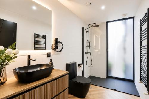 a bathroom with a black sink and a shower at Palheiro 81 Ocean View in Costa Nova