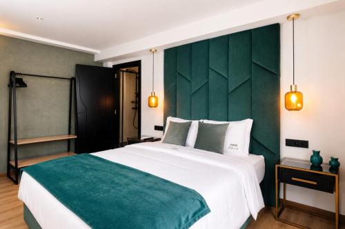 a bedroom with a large bed with a green headboard at Palheiro 81 Ocean View in Costa Nova