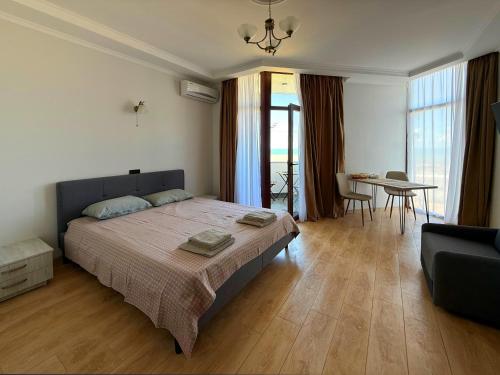 ein Schlafzimmer mit einem Bett, einem Tisch und einer Couch in der Unterkunft SofiCoast in Gonio