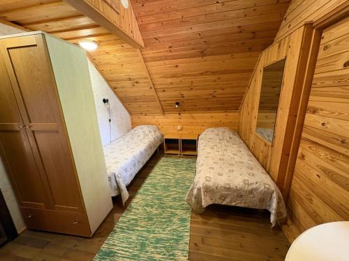 a room with two beds in a wooden cabin at Rõuge Suurjärve Külalistemaja in Rõuge