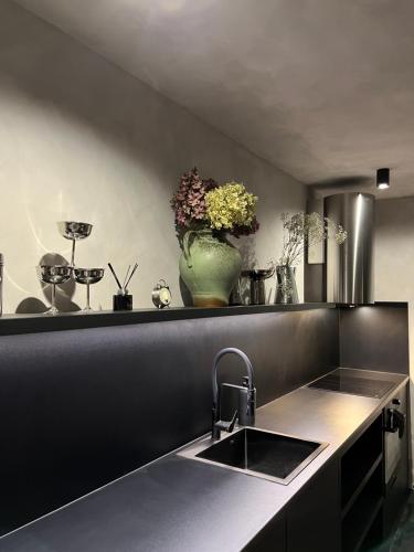 a kitchen with a sink and a vase of flowers at Pod Śnieżnymi Kotłami in Piechowice
