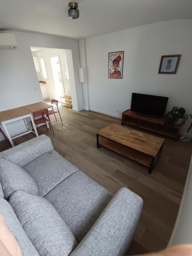 a living room with a couch and a coffee table at Appartement Neuf avec Balcon in Hendaye