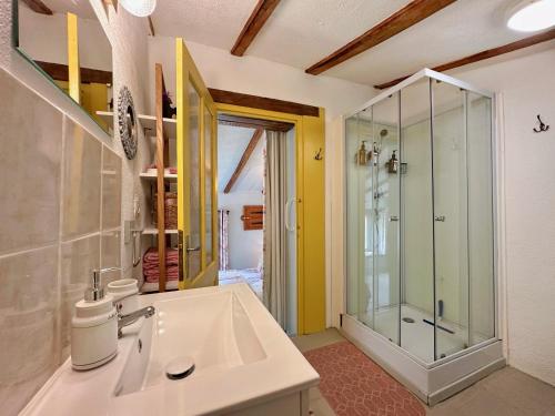 a bathroom with a sink and a glass shower at La Colline de Tilleul - Les Deux Puits - Cosy Cottage with swimming pool near Aubeterre in Saint-Romain