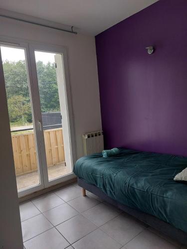 a bedroom with a bed and a purple wall at Pavillon - T2 Duplex avec Terrasse et Parking in Montagnat
