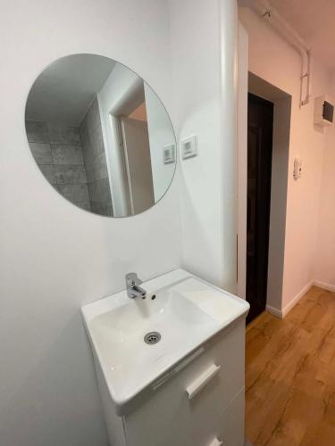 a bathroom with a white sink and a mirror at The Urban Nest apartament in Giurgiu