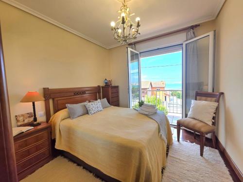 a bedroom with a bed and a window and a chair at Apartamento Ora al Mare - 32002 in Pedreña
