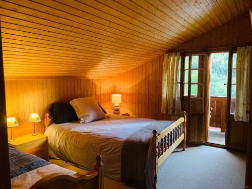 a bedroom with two beds in a wooden room at Chalet Royal in Les Diablerets