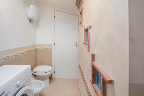 a white bathroom with a toilet and a sink at The Lake View - Terrazza Panoramica Vista Lago in Marta