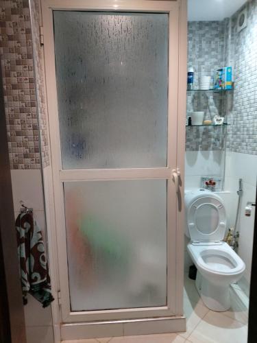 a bathroom with a toilet with a sliding glass door at Bouznika DREAMS in Bouznika