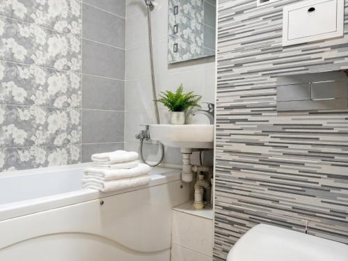 a bathroom with a sink and a toilet and a bath tub at New stail centru in Bălţi