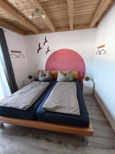 a bedroom with two beds and a red headboard at Ferienhaus Seeblick in Rheinsberg